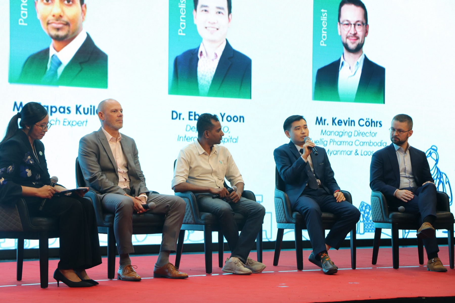 Five panellists on stage under a slide naming them, at a EuroCham Cambodia forum
